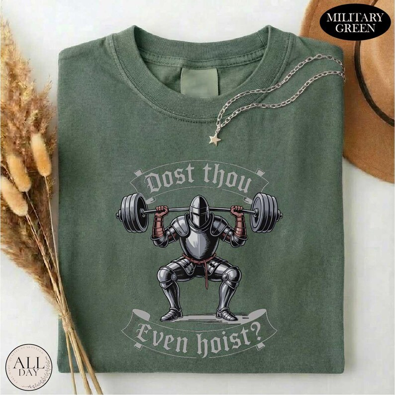a green t-shirt with a graphic design depicting a knight lifting a barbell, accompanied by the text "Dost thou even hoist?"