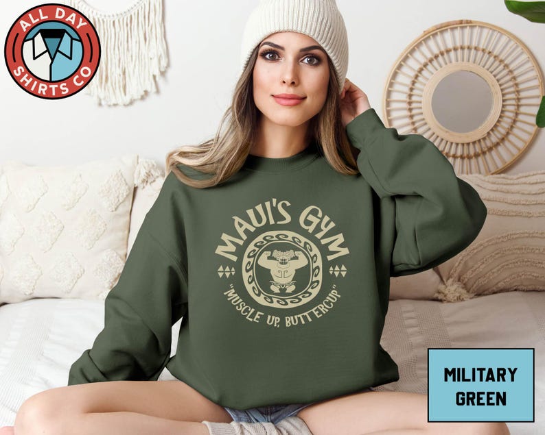 a woman sitting on a bed wearing a green sweatshirt