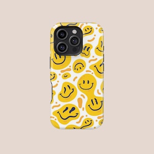 May include: A white phone case with a repeating pattern of yellow smiley faces. The smiley faces have a retro, wavy design and are set against a white background. The case has a glossy finish and a camera cutout.