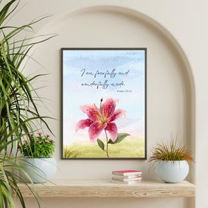 May include: Framed art print featuring a watercolor painting of a pink lily with a green stem and leaves. The print includes the text "I am fearfully and wonderfully made. - Psalm 139:14" against a blue and green background.
