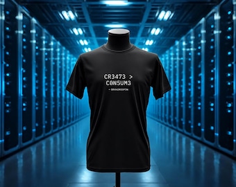 Op de afbeelding: Een zwart t-shirt met korte mouwen en witte tekst op de borst met de tekst CR3473 > C0N5UM3 en een kleinere regel eronder met - BRANDR3OFIN. Het kledingstuk wordt getoond op een paspop-torso tegen een wazige serverruimte-achtergrond.