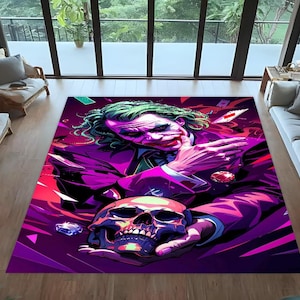 Könnte beinhalten: Rechteckiger Teppich mit einer lebendigen Illustration des Jokers, der einen Schädel hält. Der Teppich zeigt ein lila und rotes Farbschema, wobei das Gesicht des Jokers und seine grünen Haare hervorstechen. Das Design umfasst Spielkarten und Diamantakzente.