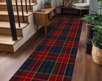 May include: A rectangular runner rug with a red, navy, yellow, and black plaid pattern. The rug is placed on a hardwood floor in a hallway, near a wooden staircase and a small wooden cabinet.
