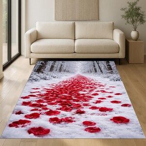 May include: A rectangular area rug featuring a winter forest scene. A path of red rose petals leads through snow-covered trees. The rug is placed in a living room setting with a beige sofa and wooden flooring.