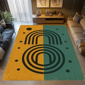 May include: A large area rug with a split design. One half is yellow with black dots and a black arched design. The other half is teal with black dots and a black circular design. The rug is rectangular.