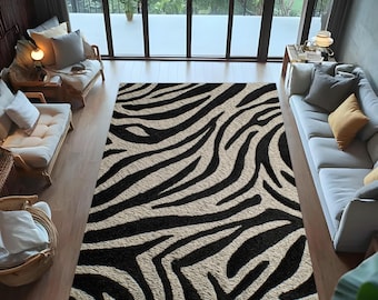 May include: A large rectangular rug with a zebra stripe pattern in black and beige. The rug is placed in a living room with light-colored furniture and large windows overlooking a green outdoor space. The rug's design adds a bold contrast to the room.
