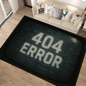 Könnte beinhalten: Eine rechteckige schwarze Fußmatte mit dem weißen Schriftzug "404 ERROR". Die Matte hat einen dunkelblauen, strukturierten Hintergrund und einen schwarzen Rand. Sie liegt auf einem hellen Holzboden.