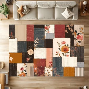 May include: A rectangular area rug with a patchwork design. The rug features various rectangular and square patterns in shades of brown, red, beige, and navy. Floral patterns and stripes are incorporated into the design. The rug is placed on a wooden floor.