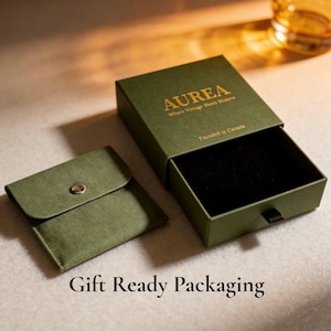 Może przedstawiać: Otwarta zielona skrzynka i mała zielona sakiewka ze srebrnym zatrzaskiem. Na pudełku złoty napis "AUREA Where Vintage Meets Modern Founded in Canada". U dołu obrazu widnieje napis "Gift Ready Packaging".