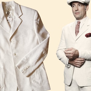 Può includere: Una giacca di lino bianco con tre bottoni e due tasche a patta. La giacca ha una vestibilità classica e aderente.