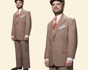 May include: A man wearing a brown suit with a red and white patterned tie and a brown cap. He is standing with his hands at his sides.