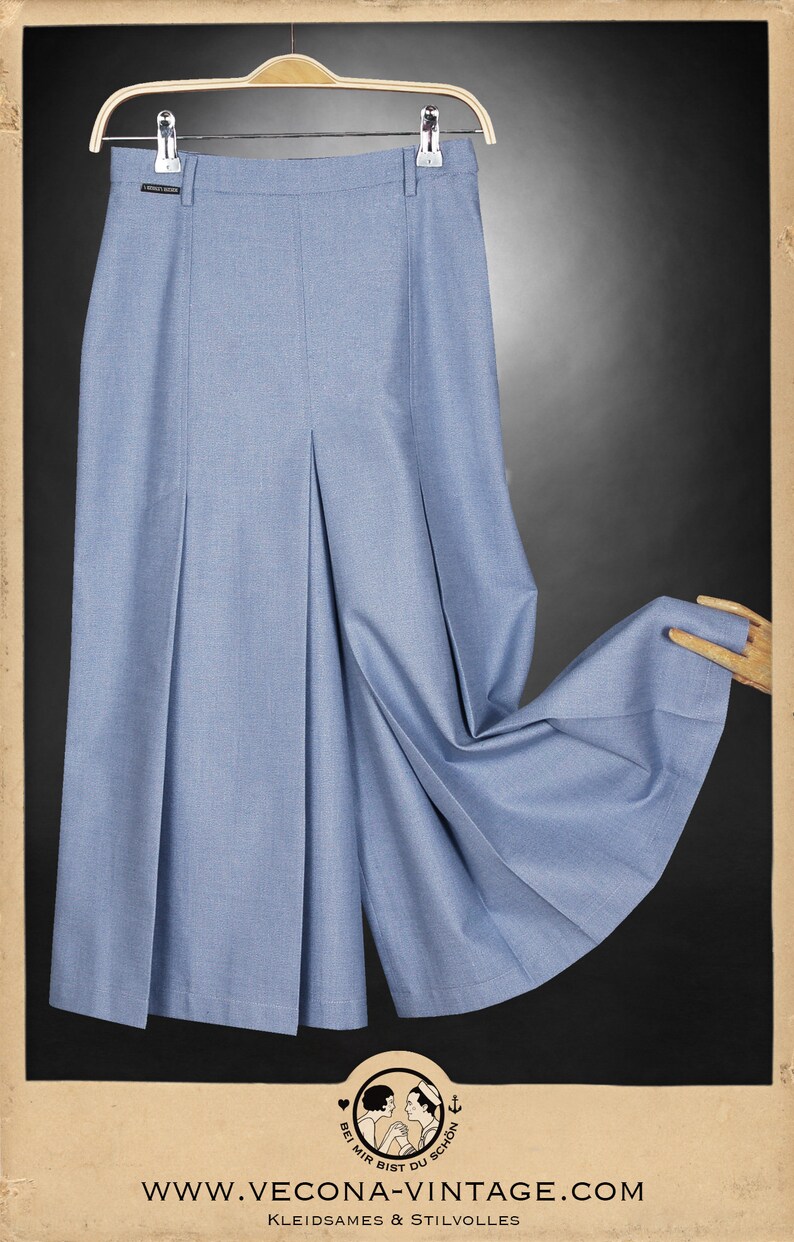 May include: A light blue pleated skirt with a high waist and a wide leg. The skirt is made of a lightweight fabric and has a relaxed fit.
