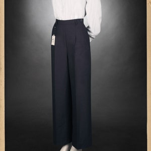 Puede incluir: Una camisa de manga larga a rayas blancas y azules con cuello blanco y un pantal&oacute;n negro de cintura alta. El pantal&oacute;n tiene pierna ancha y est&aacute; hecho de una tela lisa.
