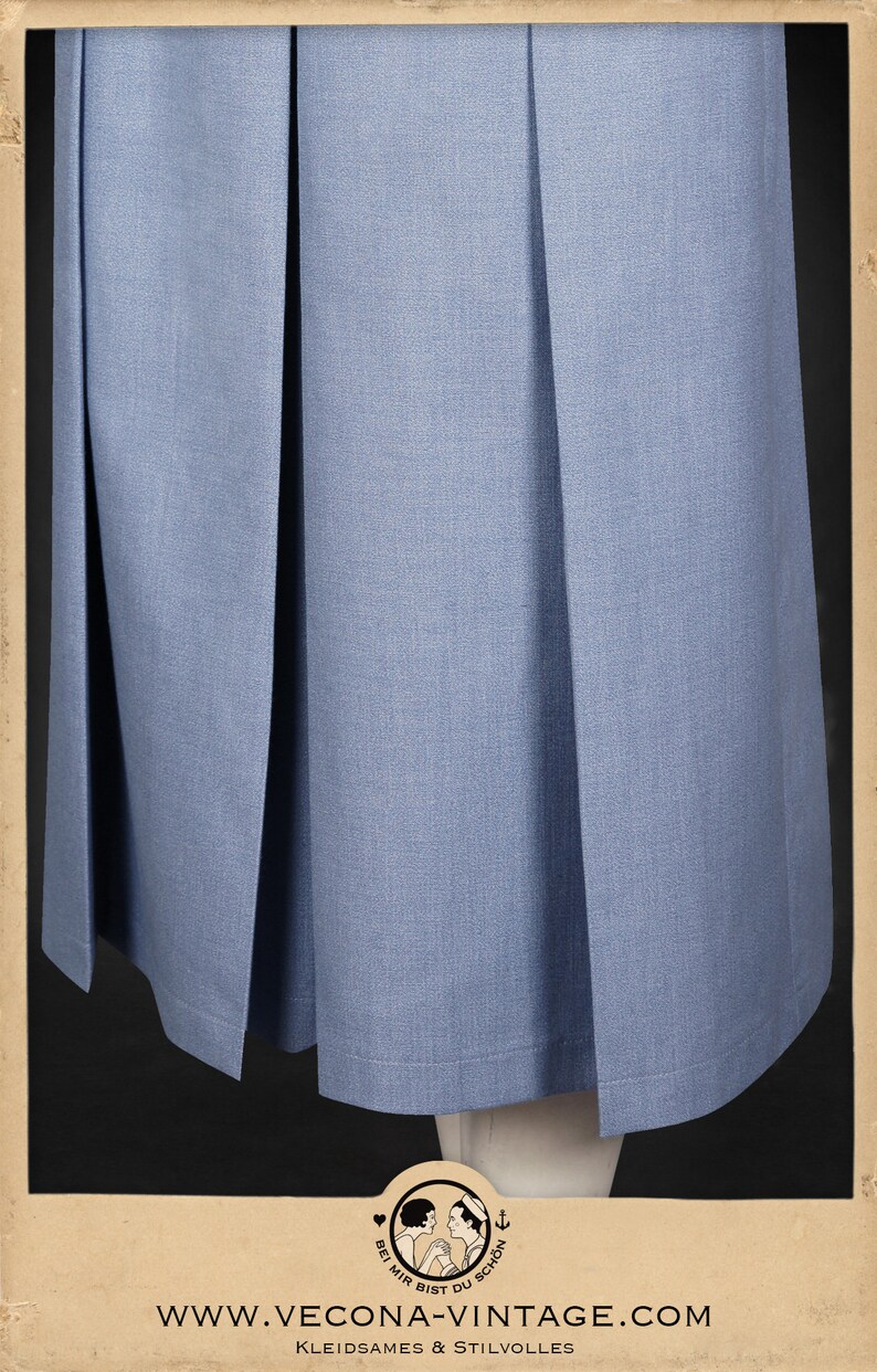 May include: A light blue skirt with pleats. The skirt is made of a smooth fabric and has a simple design. The skirt is hemmed with a thin black line. The image includes the text "www.vecona-vintage.com" and "Kleidsames & Stilvolles".