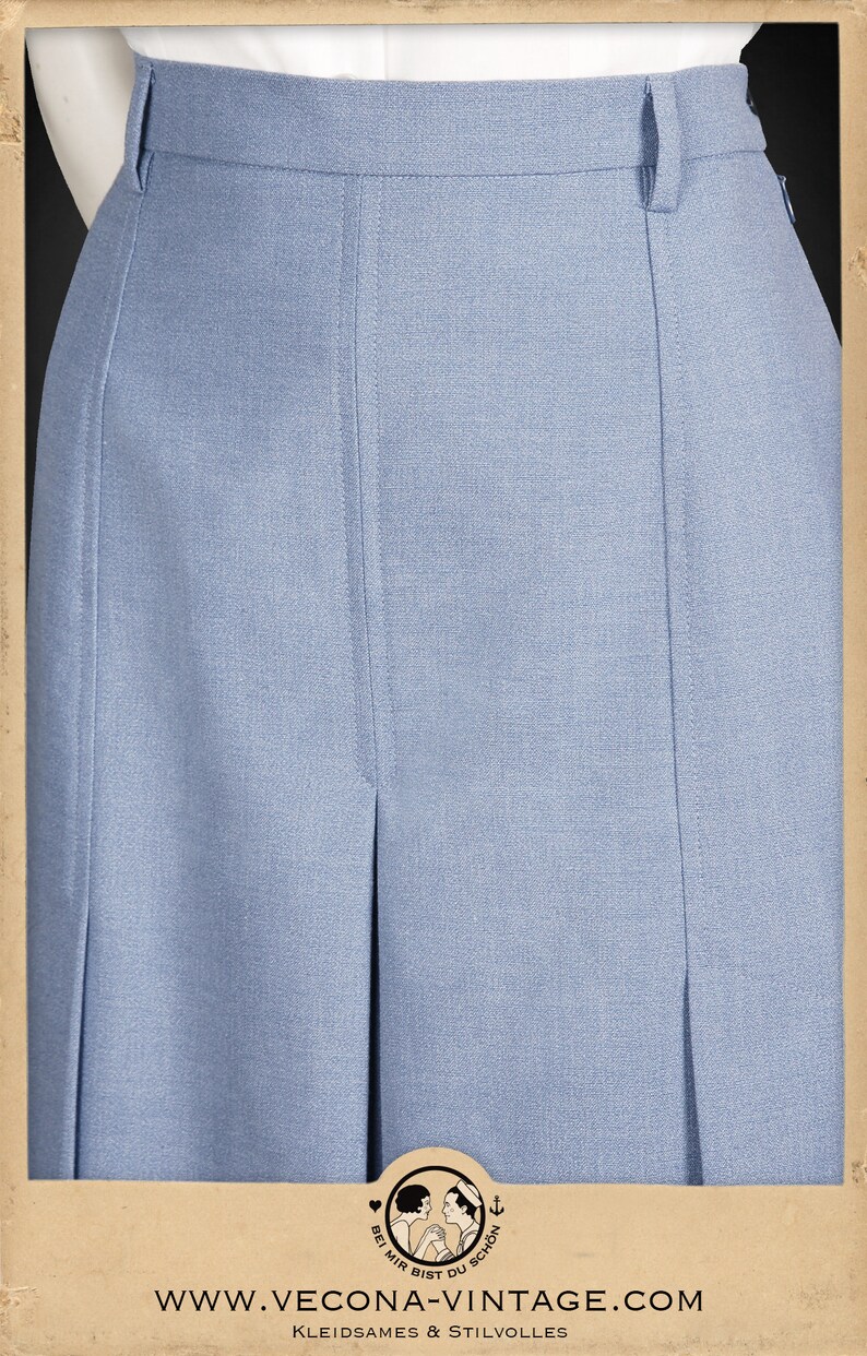 May include: A light blue skirt with pleats and a high waist. The skirt is made of a smooth, textured fabric.