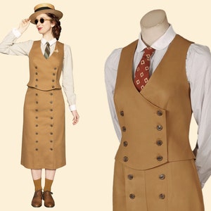 K&ouml;nnte beinhalten: Ein beigefarbener Anzug im Vintage-Stil, bestehend aus einer doppelreihigen Weste und einem passenden Rock. Die Weste hat dunkle Kn&ouml;pfe und wird mit einem gestreiften Hemd und einer gemusterten Krawatte kombiniert. Das Outfit wird durch einen Strohhut und eine Sonnenbrille erg&auml;nzt.