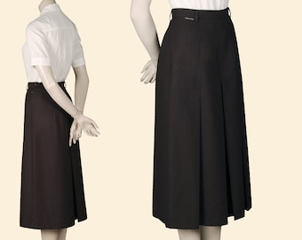 May include: A brown pleated skirt with a center back vent. The skirt is knee-length and has a waistband with a belt loop.