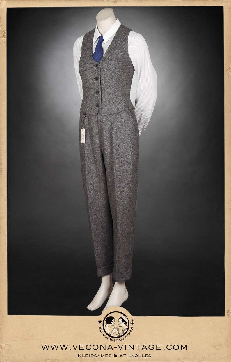 Puede incluir: Un chaleco de tweed gris con una camisa blanca abotonada y una corbata azul. El chaleco tiene cuello en V y seis botones. La camisa tiene un patr&oacute;n a rayas. La corbata tiene un patr&oacute;n de rayas diagonales. El atuendo est&aacute; en un maniqu&iacute;.