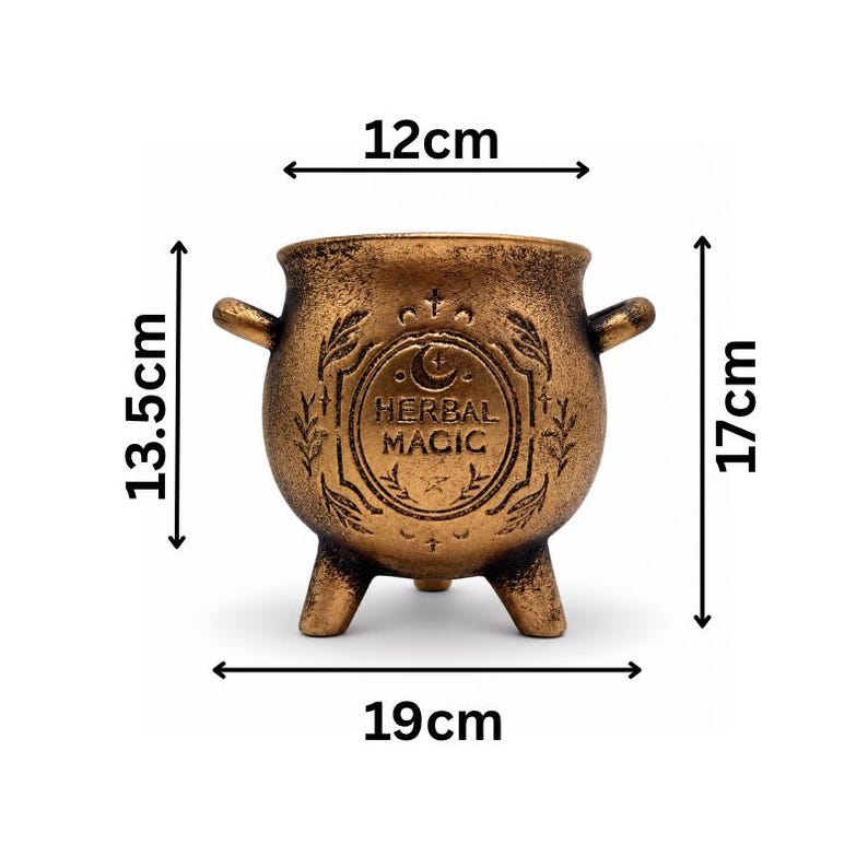 May include: A bronze-colored cauldron with three legs and two side handles, featuring the embossed text HERBAL MAGIC and celestial symbols. Dimensions are 12cm wide at the opening, 19cm wide overall, 13.5cm tall at the body, and 17cm total height.