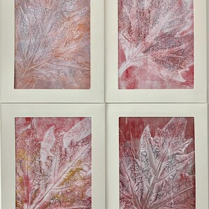 May include: Four framed art prints featuring leaf impressions. The leaves are rendered in shades of white, red, and orange, with intricate vein details. Each print is set within a white frame, creating a cohesive and artistic display.