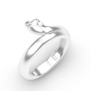 May include: A silver ring with a fluid, curved form. The ring has a smooth, polished band that elegantly curves around. The top of the ring has a small, square-shaped setting, ready for a gemstone. The ring is set against a white background.