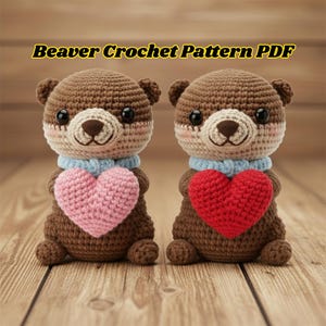 May include: Two crocheted beaver figures with brown bodies, light beige faces, and black eyes. Each beaver holds a heart, one pink and one red. They wear blue scarves. The text "Beaver Crochet Pattern PDF" is at the top.