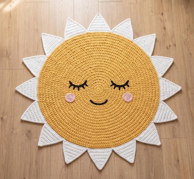 Puede incluir: Alfombra de ganchillo amarilla hecha a mano con forma de sol sonriente. El sol tiene rayos blancos, pesta&ntilde;as negras, una sonrisa negra y mejillas rosas. Un art&iacute;culo decorativo para una habitaci&oacute;n infantil.