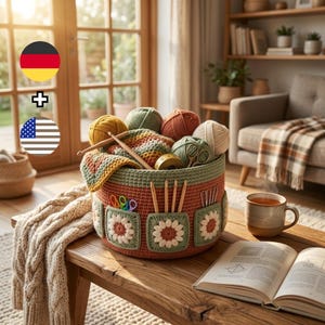 Puede incluir: Una cesta de almacenamiento redonda tejida a ganchillo en tonos terracota y verde salvia, con bolsillos exteriores decorados con cuadrados de la abuela florales en blanco y rosa. La cesta contiene ovillos de lana, ganchillos y tijeras.