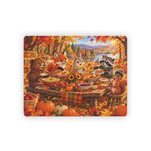 May include: A rectangular jigsaw puzzle featuring an autumn forest scene with a bear, fox, rabbit, raccoon, and squirrel gathered around a wooden table filled with pumpkins, apples, corn, and pies, surrounded by vibrant orange and red fall foliage.