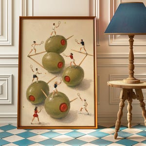 Op de afbeelding: Een ingelijste kunstdruk met een surrealistische illustratie van verschillende groene olijven met rode pimenten, die elk dienen als speelveld voor kleine figuren die tennissen met rackets en ballen. Het kunstwerk zit in een dunne bruine houten lijst.