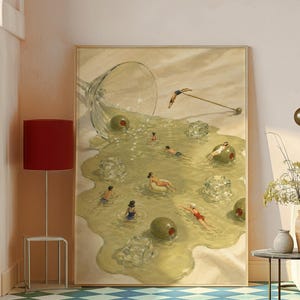 May include: A framed rectangular wall art print depicting a spilled martini glass on a light surface. The liquid forms a pool containing several people swimming, floating on an inflatable ring, and diving, alongside large green olives and ice cubes.