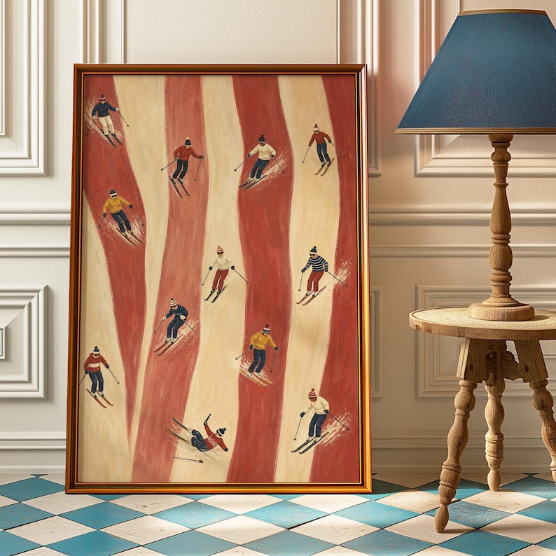May include: A framed vertical wall art print featuring a repeating pattern of wavy vertical stripes in alternating shades of deep red and cream. The artwork depicts eleven small figures skiing downhill, each wearing winter clothing and hats.