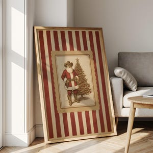 May include: Framed Christmas art print featuring a cowboy Santa Claus next to a decorated Christmas tree. The artwork is set against a background of red and cream vertical stripes, framed in wood.