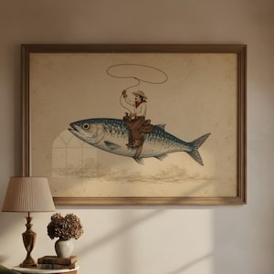 Può includere: Una stampa d'arte incorniciata che presenta un'illustrazione in stile vintage di una persona con cappello da cowboy e abbigliamento western, che cavalca il dorso di un grande pesce tenendo un lazo sopra la testa, su sfondo color carta beige.