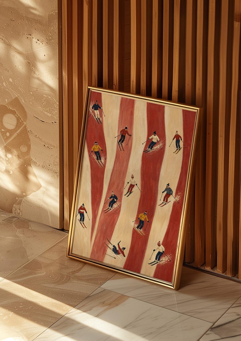 May include: A framed rectangular wall art print featuring a repeating pattern of vertical red and cream stripes. The artwork depicts eleven small figures of skiers in various colorful winter outfits, each using poles and skis on the striped background.