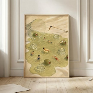 May include: A framed art print depicting a spilled martini glass with olive-colored liquid spreading across a surface. Small figures in swimwear are swimming in the liquid, accompanied by floating ice cubes and whole green olives.