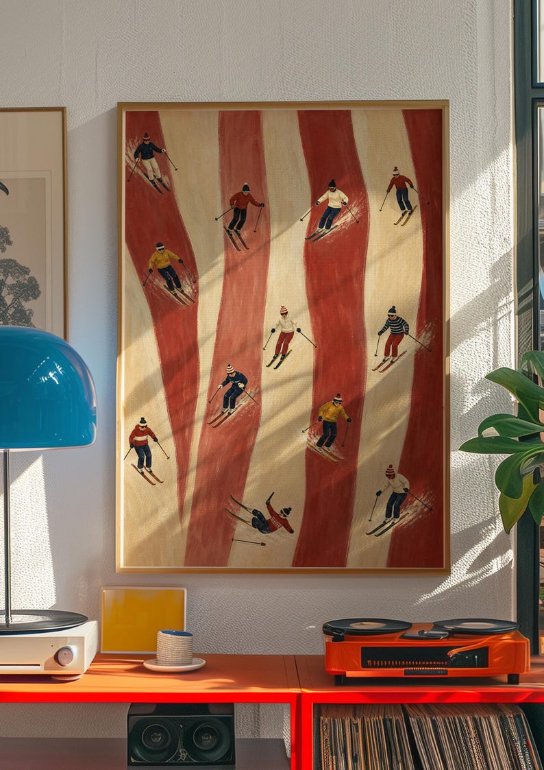 May include: A framed vertical wall art print featuring a repeating pattern of vertical red and cream stripes with small illustrations of skiers in various colorful outfits and hats skiing down the slopes across the entire composition.