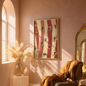 May include: A framed vertical wall art print featuring a repeating pattern of red and cream vertical stripes with small painted figures of people skiing in various colorful winter outfits, including hats, jackets, and trousers, across the surface.