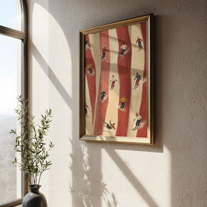 May include: A framed rectangular wall art print featuring a vertical pattern of alternating cream and deep red stripes. The artwork depicts multiple small figures skiing down the slopes in various colorful winter outfits and gear.