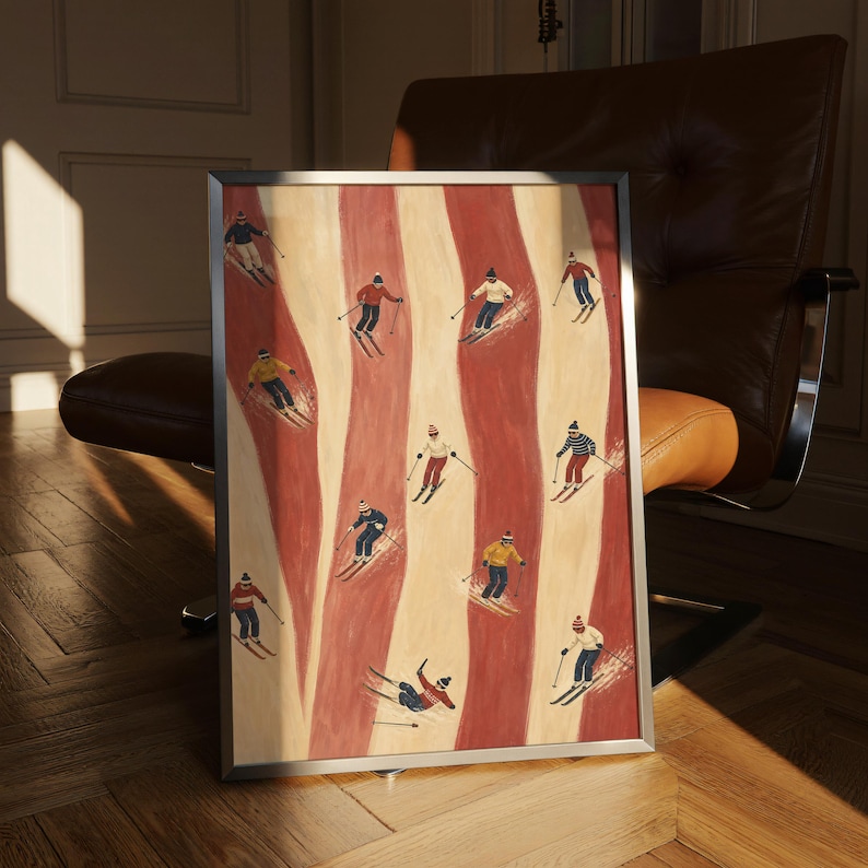 May include: A framed rectangular art print featuring a repeating pattern of skiers on a background of vertical wavy red and cream stripes. The skiers wear colorful winter clothing, including hats, sweaters, and pants, while using poles and skis.