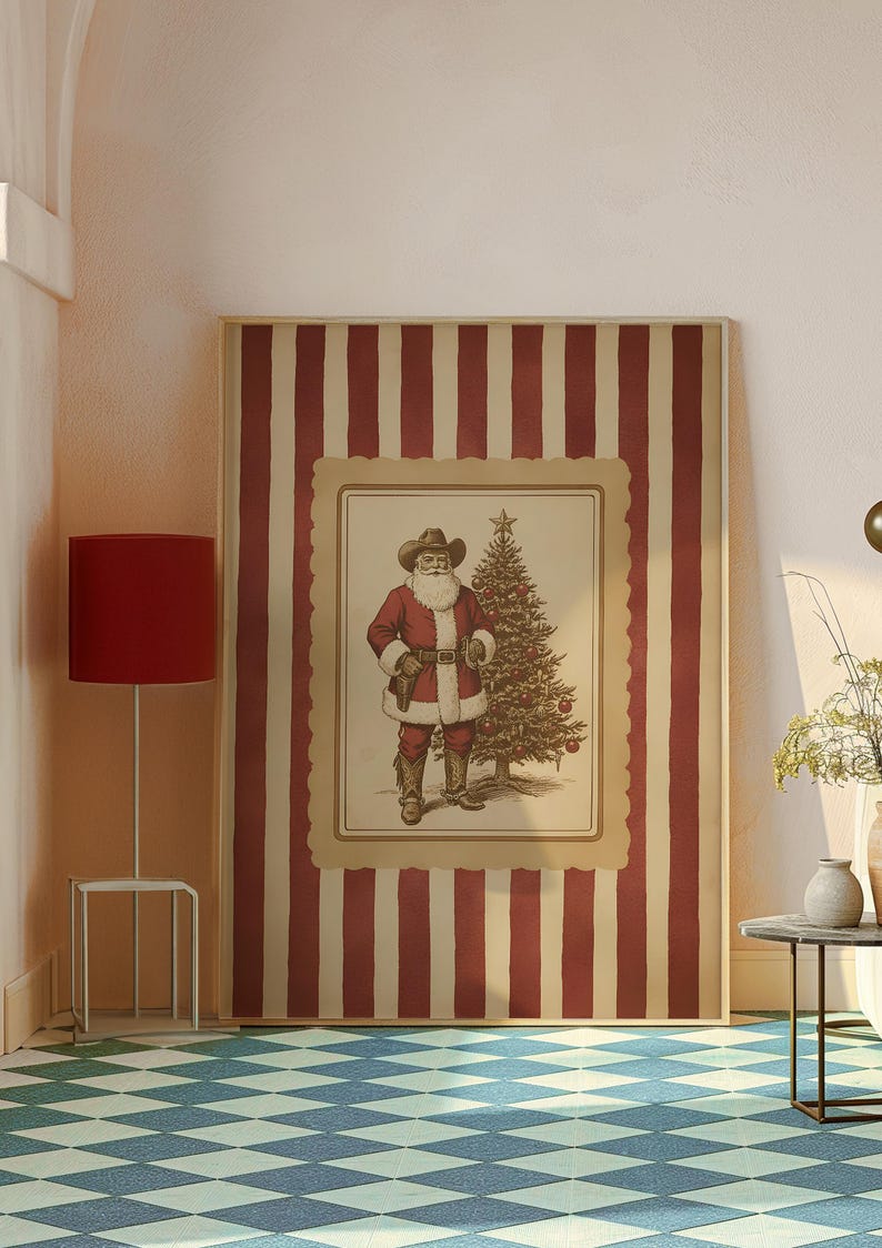 May include: A framed Christmas print featuring Santa Claus in a cowboy hat and attire, standing next to a decorated Christmas tree. The print is set against a red and cream striped background.