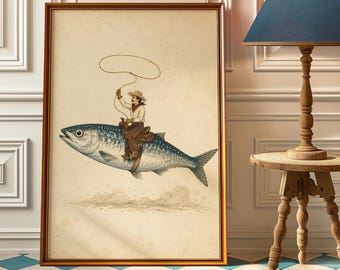 May include: A framed wall art print featuring a vintage-style illustration of a cowboy wearing a hat and neckerchief, riding on the back of a large fish while holding a lasso. The artwork has a cream-colored background with subtle dust effects.