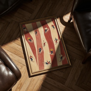 May include: A rectangular framed print featuring a repeating pattern of skiers in various colored winter clothing, including red, yellow, blue, and white, set against alternating vertical stripes of cream and muted red on a textured background.