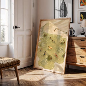 May include: A framed art print featuring a surreal illustration of a spilled martini glass. The liquid forms a pool containing small figures swimming, floating on green olives, and lounging on ice cubes, with a cocktail umbrella resting nearby.