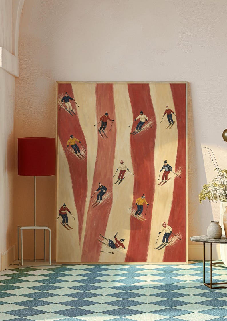 May include: A rectangular framed wall art print featuring a repeating pattern of vertical wavy red and cream stripes. The artwork depicts multiple small figures skiing in various poses, wearing colorful winter clothing, hats, and goggles.
