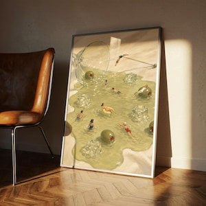 May include: A framed rectangular art print featuring a surreal illustration of a spilled martini glass on a sandy surface. The spilled liquid forms a pool containing swimming figures, large green olives, and translucent ice cubes.