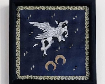 Dwa razy więcej | Dwugłowa krowa z gwiazdami i księżycem, średniowieczny haft igłowy w czarnej drewnianej ramie