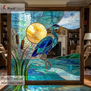 May include: Stained glass panel featuring a blue heron standing in water, with a yellow sun in the background. The artwork is framed in a dark wood. The image includes the text "Digital Download PDF | SVG | PNG".