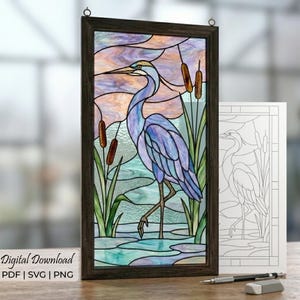 May include: Stained glass panel featuring a blue heron in a marsh scene. The artwork is framed in dark wood and includes cattails and water. The image also includes a line drawing of the heron and the text "Digital Download PDF | SVG | PNG".