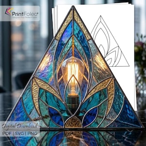 May include: A triangular stained glass lamp featuring a lotus-inspired pattern in shades of blue, teal, and gold. The lamp contains a single glowing Edison-style light bulb. Behind the lamp is a white paper template showing the line art design.